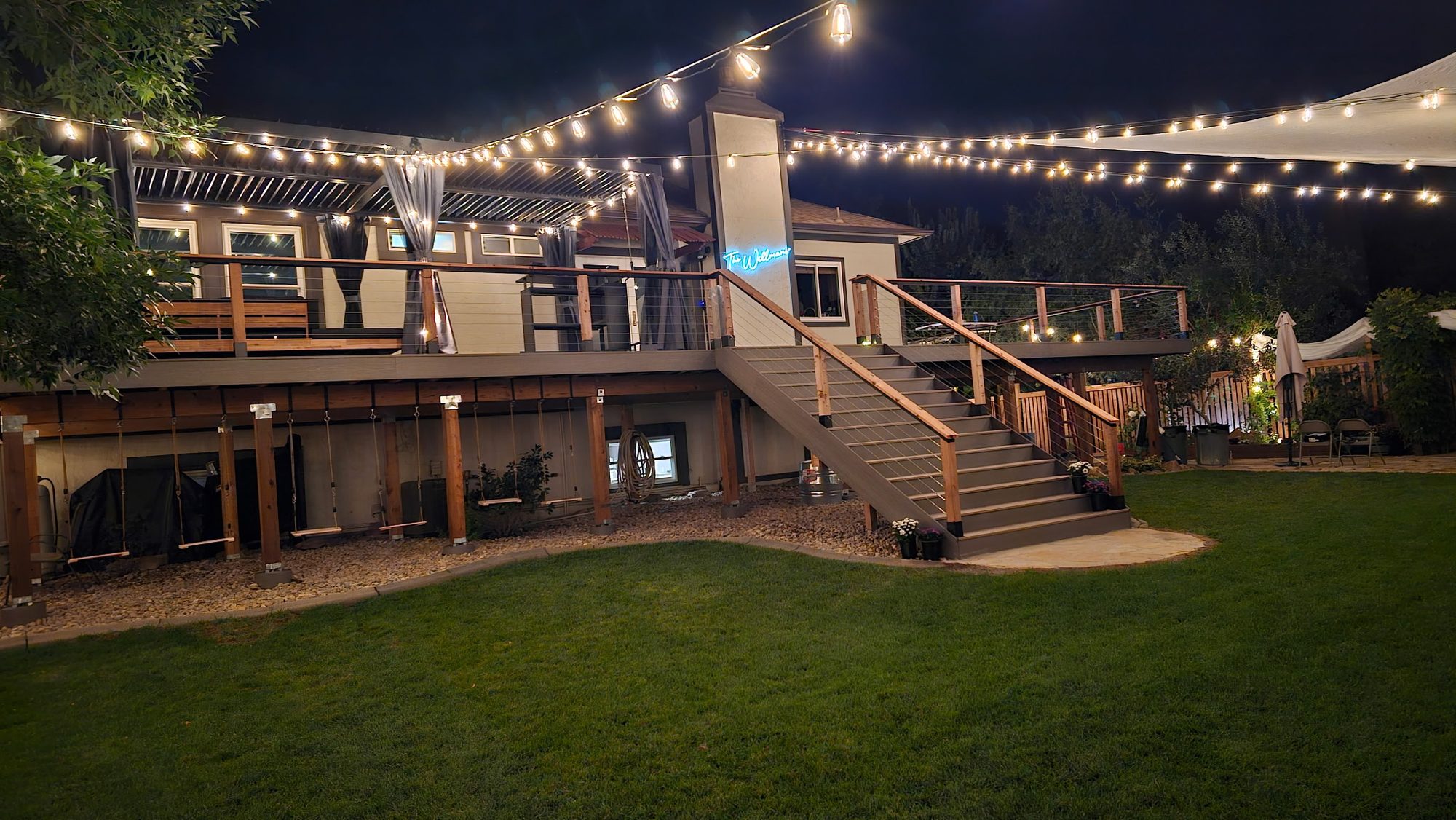 Two-level deck with stairs and string lights at night