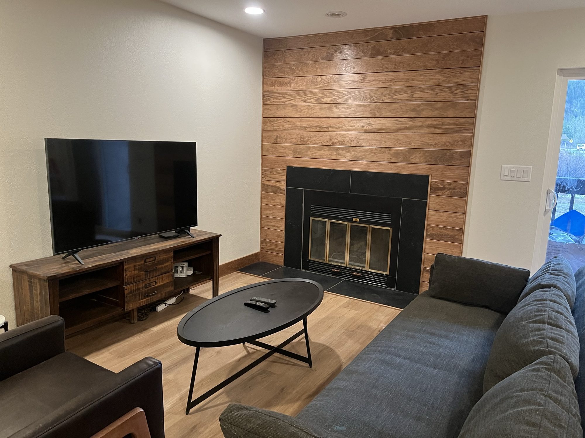 Living room with a wood plank fireplace wall and new flooring