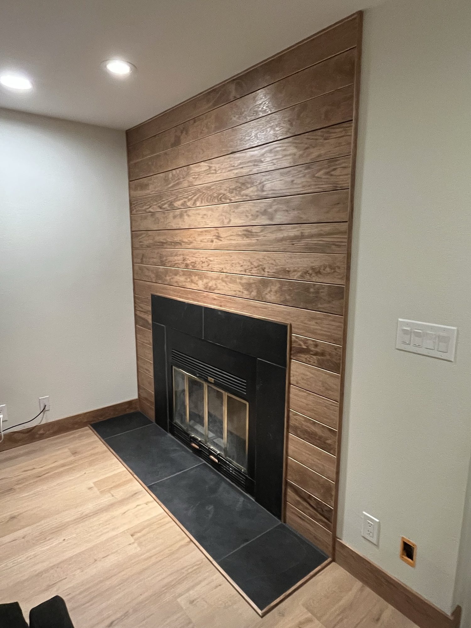 Fireplace with a full-height wood plank surround and tile hearth